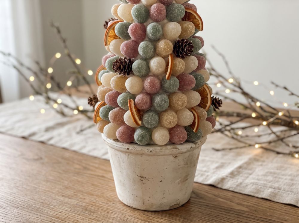 A cone-shaped candy centerpiece covered in colorful gumdrops