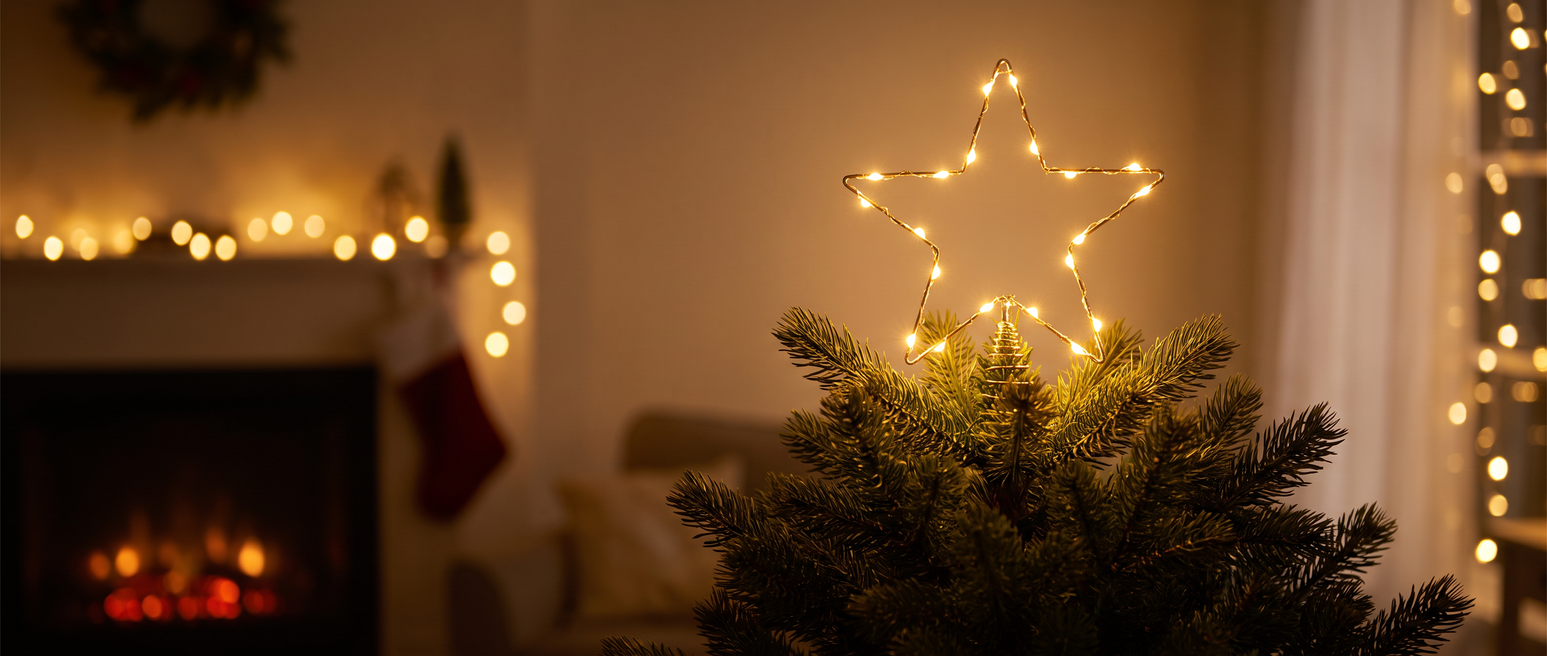 A wire star topper glowing on a Christmas tree